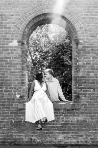 Young lovers photographed in a sweet moment by the brick wall.