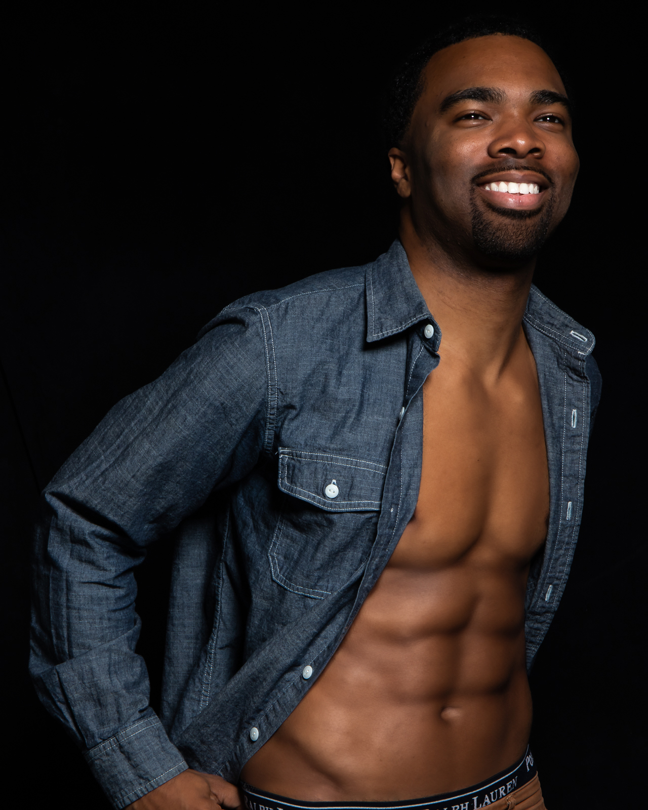 Sexy black man with shirt off studio portrait fashion photoshoot