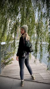 Woman photographer wearing WANDRD Rouge 6L sling bag with Canon R6 MarkII mirrorless camera