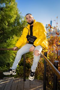 Person posing in a bright outfit against a park backdrop in New York.