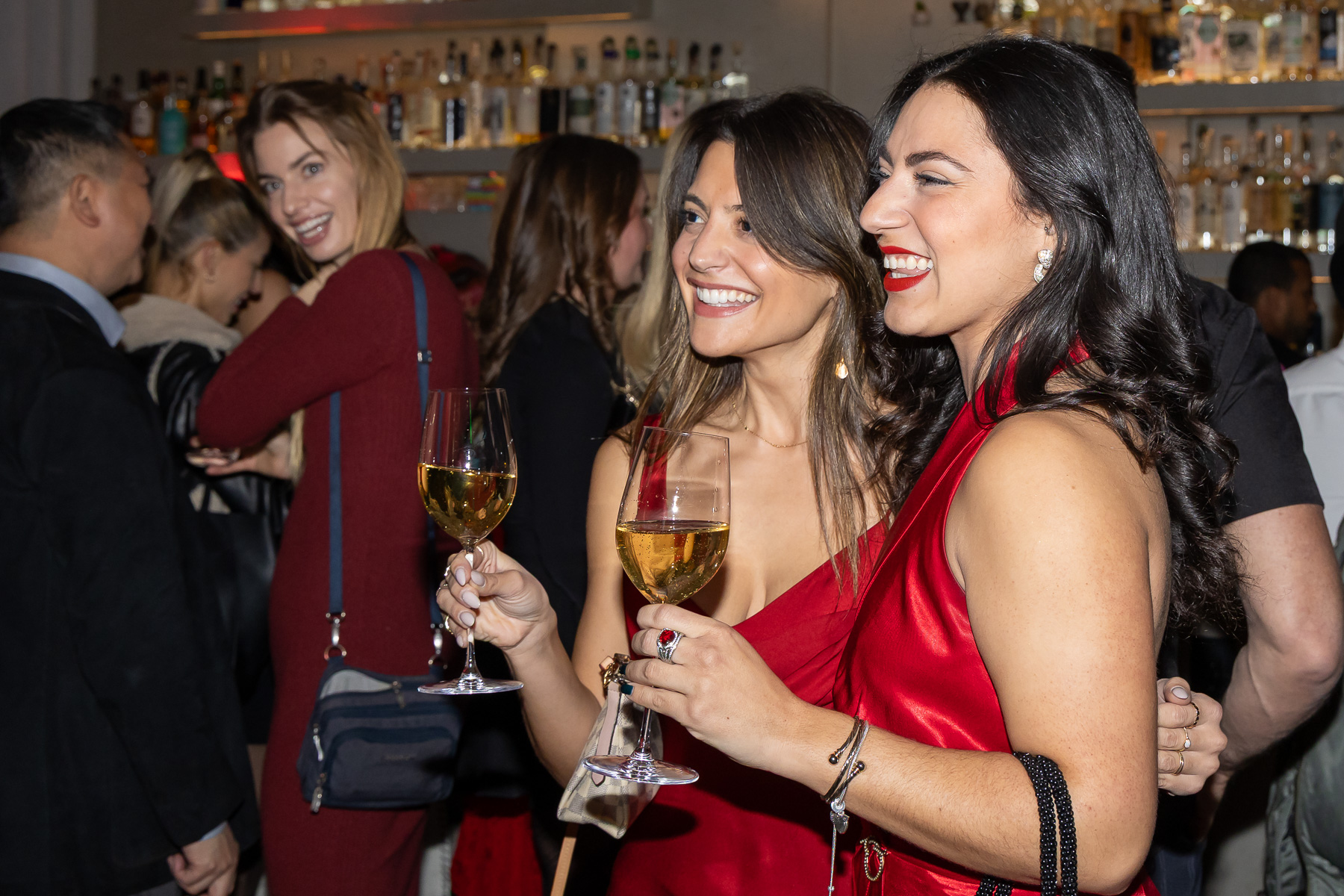 Guests smiling at a Christmas party in a Brooklyn hotel bar.