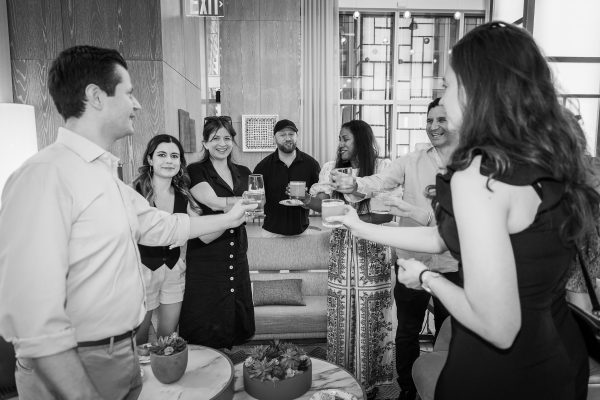 Group of people clinking glasses during a toast.